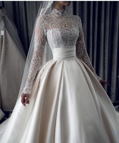 a woman wearing a wedding dress with long sleeves