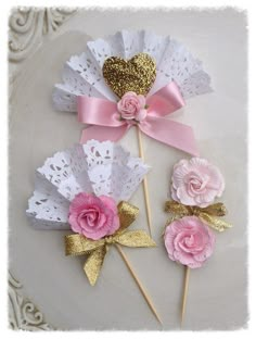 three pink and white flowers on top of each other with gold glitter hearts in the middle