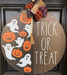 a trick or treat door hanger with pumpkins on it