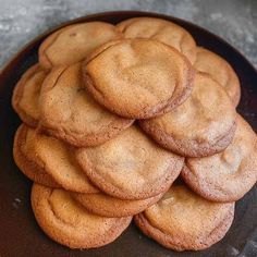 a pile of cookies sitting on top of a black plate