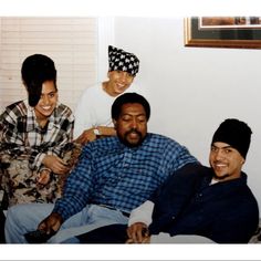 a group of people sitting next to each other on a couch in a living room