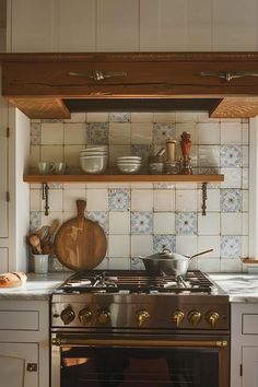 a stove top oven sitting inside of a kitchen next to a wooden shelf filled with pots and pans