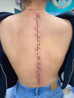 the back of a woman's lower back tattoo with writing on her left side