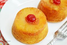 two pineapple upside down cakes on a white plate with a fork next to it