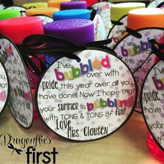 several different colored bottle caps with sayings on them and ribbons tied around the top