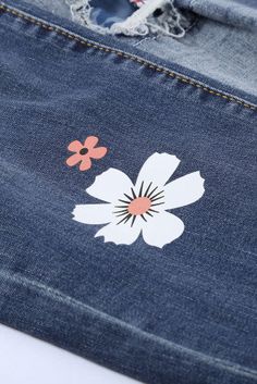 a pair of jeans with flowers painted on the side and holes in the back pocket