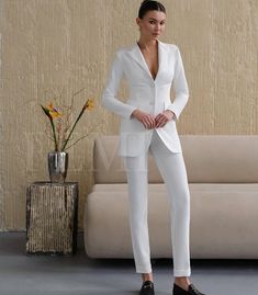 Feminine Boutique- is a women's clothing brand creating elegant formal outfits for confident women. Our designs highlight femininity and refined taste in every detail. This elegant pantsuit features a lined blazer and straight-leg trousers with a subtle cuff at the hem. The two-button blazer highlights the silhouette, adding a touch of refinement, while the relaxed-fit trousers ensure comfort and ease of movement. Model "Kate " Description:  * Fabric: premium crepe diagonal ( 65% cotton, 30% polyester , 5% elastan)  * Blazer: Lined, two-button closure  * Back length: 76 cm / 29.9 inches  * Sleeve length: 62 cm / 24.4 inches  * Trousers: Straight-leg with a subtle cuff  * Side seam length: 102 cm / 40.2 inches  * Color: white  -If necessary, we sew the color - black, mokko, blue  *write for Kate Model, Elegant Pants Suits, Wedding Women, Confident Women, Formal Outfits, Elegant Sets, Confident Woman, Fitted Trousers, Straight Leg Trousers