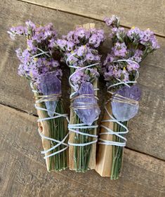 three bundles of lavender flowers tied up with twine on wooden planks, ready to be used as an altar decoration