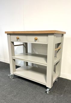 a white wooden table with two drawers on wheels