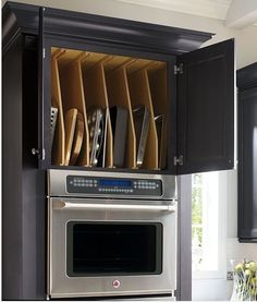 the kitchen cabinets are open with knives and pans in them on top of each other