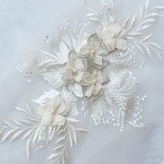 white flowers and leaves are on the fabric