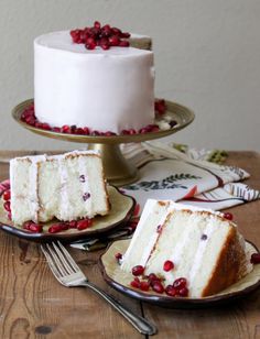 two slices of white cake on plates with cranberries