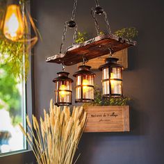 the hanging lantern is made from wood and has four lights on each side, along with some plants