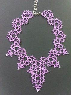 a purple crocheted necklace on a black surface