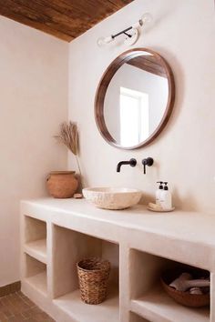 a bathroom with a sink, mirror and shelves on the wall next to each other