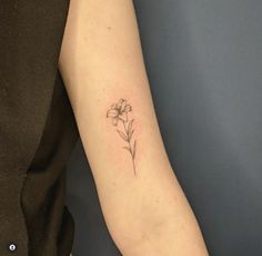 a woman's arm with a single flower tattoo on the left side of her arm