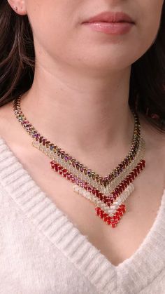 a woman wearing a red and white necklace with multicolored beads on it's neck