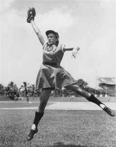 an old photo of a woman in the air with a baseball glove on her hand