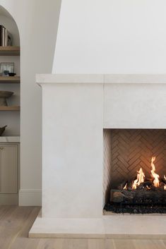 a fire place in the middle of a room with shelves on either side and bookshelves above it