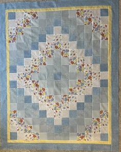 a blue and yellow quilt with flowers on it