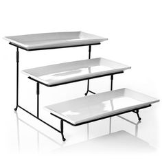 three tiered white trays with black legs and one shelf holding two empty plates