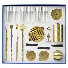 an assortment of kitchen utensils in a blue and white box with gold accents