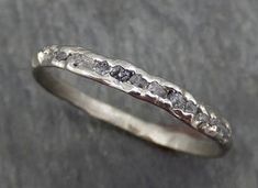 a silver ring with white diamonds on it