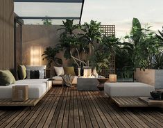 an outdoor living area with couches, tables and potted plants on the deck