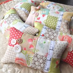 a close up of a pillow on a bed with buttons and measuring tape around it