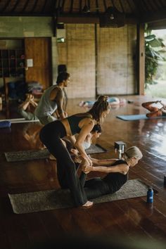 a group of people doing yoga in a room