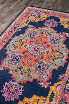 a colorful rug with an intricate design on the middle and bottom, in front of a wooden floor