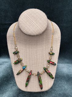 This womens beaded necklace is a little bit of sparkle, a little bit of shimmer, and a pop of vivid color from eight gorgeous mosaic beads ranging in size from 18mm to 45mm. The blue, green, red, and purple shades used to create these unique mosaic beads make a stunning statement in this one of a kind necklace design. Not only does the beauty of these beads stand out on their own in this necklace, but they work exquisitely to bring out the eye catching iridescent colors of the  gold pearlized se Adjustable Beaded Chain Necklaces For Festive Occasions, Adjustable Beaded Necklaces For Festive Occasions, Czech Glass Beaded Chain Dangle Necklaces, Czech Glass Beaded Chain Dangle Necklace, Adjustable Czech Glass Necklaces With Dangling Beads, Adjustable Czech Glass Necklace With Dangling Beads, Multicolor Faceted Beads Dangle Necklaces, Multicolor Dangle Necklaces With Faceted Beads, Party Jewelry With Czech Glass Beads