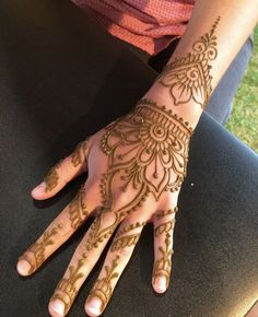 a woman's hand with hennap on it and her hands in the shape of a flower