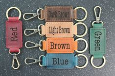 four different colored leather keychains with the words dark brown, light brown, and brown on them