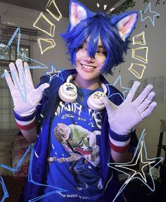 a person with blue hair and cat ears holding up their hands in front of the camera