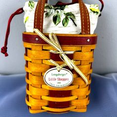 a yellow and brown basket with a tag on the side that says longridger little shoppe