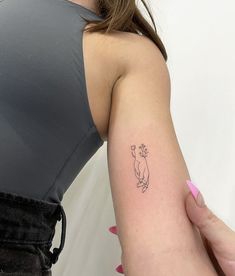 a woman's arm with a small tattoo on the left side of her arm