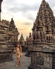 a woman standing in front of many stone structures