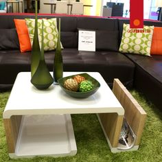 a white table topped with a bowl of food next to two green vases