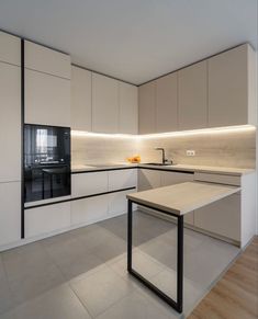 an empty kitchen with white cabinets and black appliances