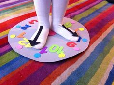 a person standing on top of a colorful rug with numbers and arrows painted on it