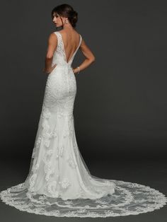 a woman in a white wedding dress with an open back and floral appliques