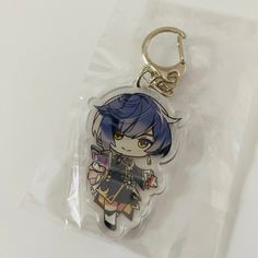 a plastic keychain with an anime character on it's front and back sides