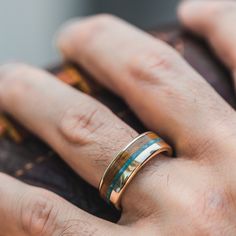 a close up of a person's hand with a ring on it