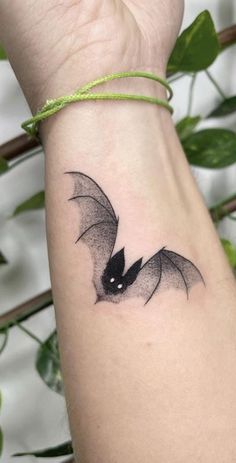 a small bat tattoo on the wrist