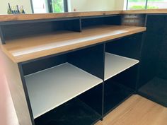 an empty counter in a room with wooden flooring and black cabinetry on the wall