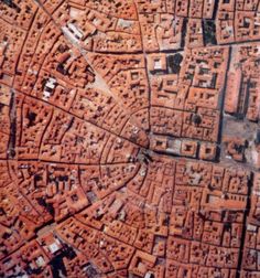 an aerial view of a city with lots of red bricks on the buildings and streets