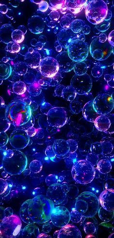 many soap bubbles floating in the air with colored lights on them, all over the ground