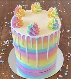 a rainbow cake with icing and sprinkles