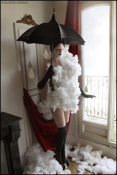 a mannequin dressed in white and black holding an umbrella